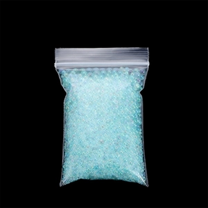 Close-up of light blue iridescent glass bubble beads in a clear plastic bag for DIY crafts