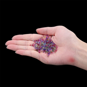 Colorful mixed mini glass bubble beads in palm for DIY resin craft and nail art decoration