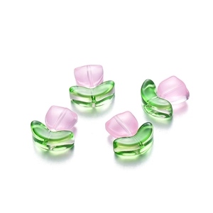Detailed macro view of semi-transparent tulip glass beads with pink petals and green leaves