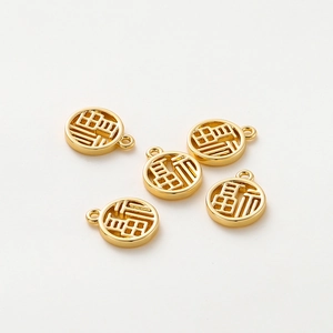 Macro detail of five 18K gold-plated Fu pendants for DIY jewelry making