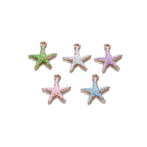 Detail van vijf gekleurde zeester hangers met gouden plating voor DIY sieraden