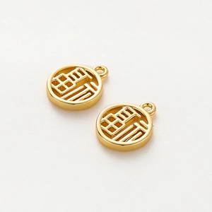 Macro shot of 18K gold-plated round Fu character charms with hollow engraving