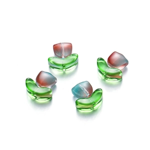 Macro view of handmade tulip glass beads with gradient pink petals and green leaves