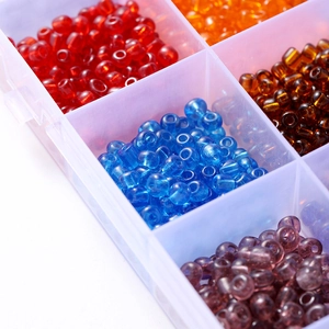 Vue macro de perles en verre coloré de 4mm dans une boîte de rangement transparente