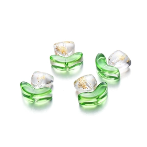 Macro detail of glass tulip flower beads with gold foil inside and green leaf base