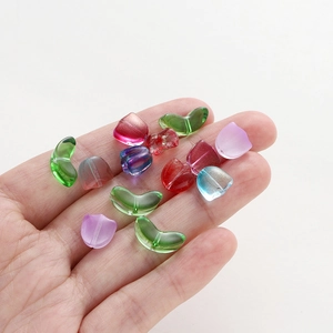 Close-up of colorful tulip-shaped glass beads held in hand for DIY jewelry making