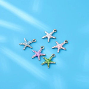 Detail van vijf kleurrijke zeesterhangers van legering voor DIY-sieraden op blauwe basis