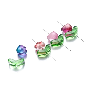 Detailed view of colorful glass tulip beads and green leaves for DIY jewelry making