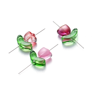 Detailed view of glass tulip beads with green leaves for DIY jewelry making