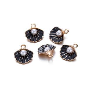 Detailweergave van vijf zwarte emaille schelphangers met goud plating en parels