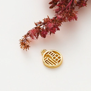 Macro view of 18K gold plated Fu character charm for DIY jewelry making and necklaces