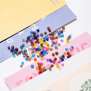 Gros plan de perles de rocaille colorées de 4mm sur papier pour bijoux artisanaux DIY