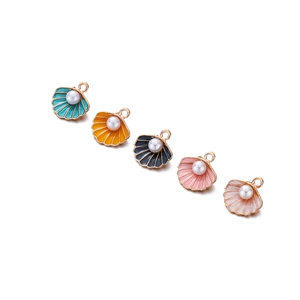 Macro-opname van vijf kleurrijke emaille schelpbedels met parels voor DIY-sieraden