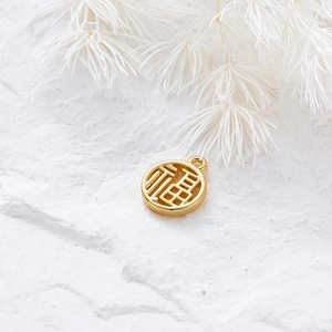 Macro view of 18K gold plated Fu pendant with hollow Chinese character on white stone