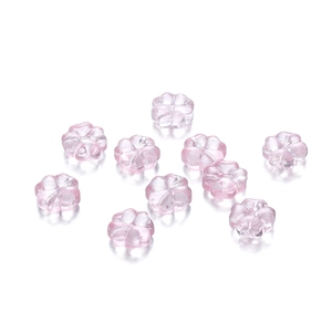 Vista macro de cuentas de vidrio trébol rosa translúcido de 10mm para joyería artesanal