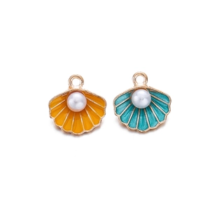 Detail van kleurrijke emaille schelphangers met goudlaagje en witte parels voor DIY sieraden