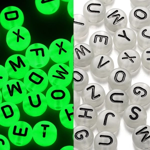 Vista macro di perline acriliche con lettere luminose che brillano al buio per gioielli DIY