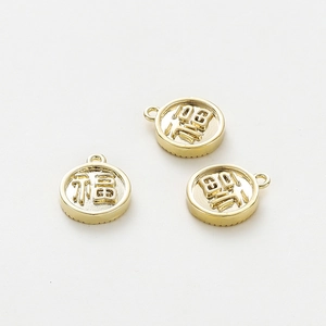 Macro detail of three 18K gold plated circular Fu charms for DIY jewelry making