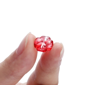 Primer plano de una cuenta de vidrio de trébol rojo de 10mm para creación de joyas DIY