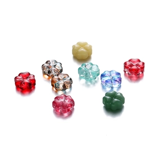 Primer plano de cuentas de vidrio coloridas de 10mm con forma de trébol para joyas DIY