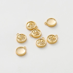 Macro shot of 18K gold-plated Fu character pendants and DIY round jewelry charms