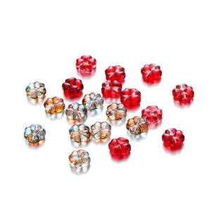 Detalle de cuentas de trébol de vidrio de 10mm en rojo y ámbar para bisutería artesanal
