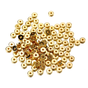 Close-up of golden flat round beads with center hole for DIY jewelry making and crafts