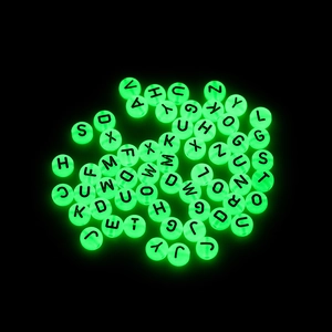 Dettaglio di perline luminose con lettere per creazione di gioielli fai-da-te verdi