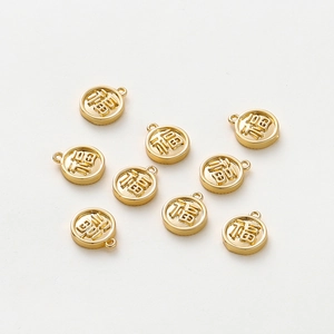 Macro shot of 18K gold plated Fu character charms for DIY jewelry making and necklaces