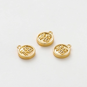 Detailed view of three round 18K gold-plated charms featuring embossed Fu character