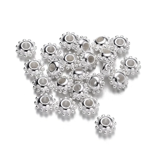 Macro shot of silver-plated CCB spacer beads with textured dotted edges for DIY jewelry