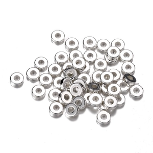 Close-up of polished silver CCB spacer beads with central holes for DIY jewelry making