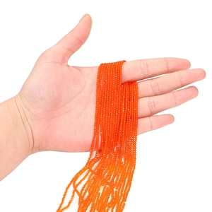 Gros plan de perles en verre facettées orange de 2mm pour la création de bijoux DIY