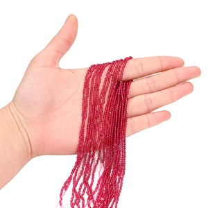 Gros plan de perles en cristal rouge foncé à facettes de 2mm pour la création de bijoux