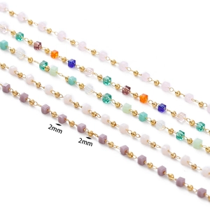 Detail of 2mm colorful crystal cube beads and golden metal round beads on chains
