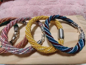 Détail de bracelets en corde tressée multicolores avec fermoirs magnétiques en métal