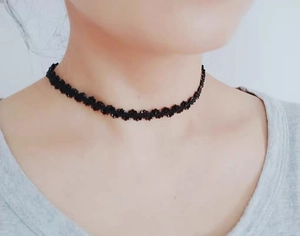 Ras du cou en dentelle noire gothique avec perles, présenté de près sur le cou de face