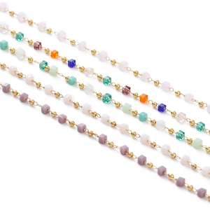 Macro detail of colorful crystal beaded chain with gold beads and square glass tassels
