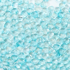 Macro shot of sky blue heart-shaped glass beads with center holes for DIY jewelry