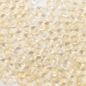 Macro view of light champagne heart-shaped glass beads with subtle glitter for DIY jewelry