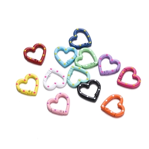 Detail of 24mm heart-shaped metal spring hooks with colorful paint and polka dot patterns