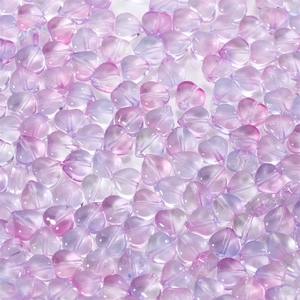 Macro shot of purple and pink gradient heart-shaped glass beads for DIY jewelry crafts