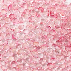 Macro shot of heart-shaped pink glass beads with gold glitter for DIY jewelry