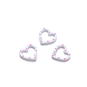 Close-up of heart-shaped spring rings with pink polka dots for DIY keychains
