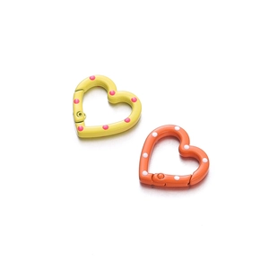 Macro shot of colorful heart-shaped spring rings with polka dot enamel finish on metal