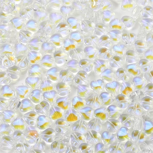 Macro shot of iridescent heart-shaped glass beads with central yellow glow for jewelry DIY