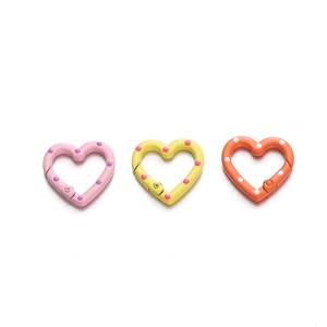 Close-up of heart-shaped spring rings in pink, yellow and orange with colorful dots