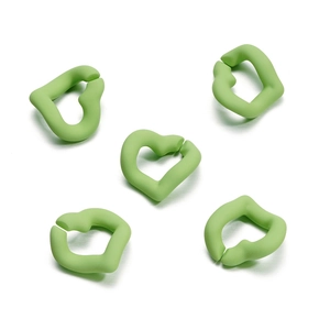 Close-up of five heart-shaped matte acrylic rings in soft macaron green for DIY jewelry