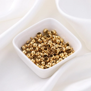 Détail macro de perles d'espacement en acier inoxydable doré 6mm avec boucle en bol