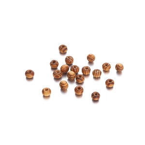 Macro shot of maple wood beads with natural brown stripes and smooth finish for DIY crafts